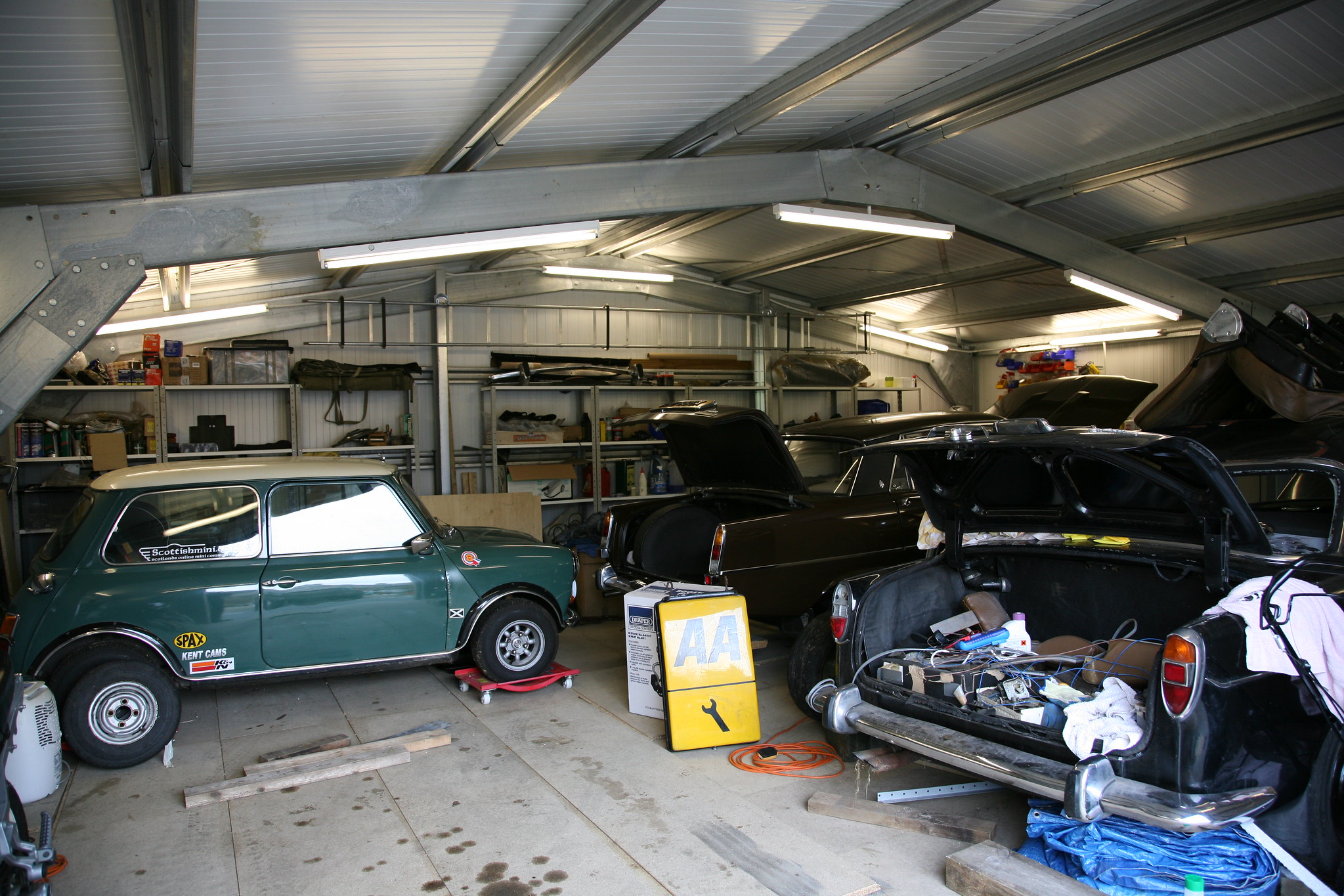 Rmmelige garage met een Mini.