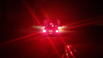 Achterlichten van een classic Mini in het donker bij de DoDa-rit van 2019