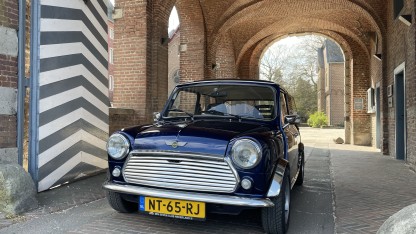 Mini onder een oude poort.